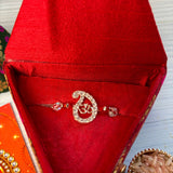 A sparkling silver om rakhi with clear crystals in a red velvet box for raksha bandhan protection and good luck