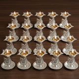 Silver plated peacock diya oil lamps with intricate embossed designs and golden oil reservoirs for home pooja mandir