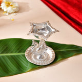 Silver plated peacock diya with intricate detailing and star-shaped oil holder for home pooja mandir and Diwali decor