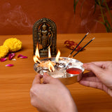 Silver plated pooja thali set with multiple compartments holding incense red powder and a decorative diya for rituals