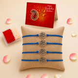 Four blue cord rose charm rakhi bracelets with silver metal floral accents on a burlap pillow for raksha bandhan gift