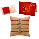 Set of four red cord rose charm rakhi bracelets with silver metal charms on burlap for brother and bhabhi gift