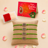 Four green cord rakhi bracelets with silver rose charm on burlap pillow for brother and bhabhi protection gift