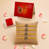 Set of four yellow cord rose charm rakhi bracelets with silver metal charms on burlap cushion for raksha bandhan gift