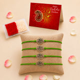 Four green cord rose charm rakhi bracelets with silver metal roses on burlap pillow for brother and bhabhi gift