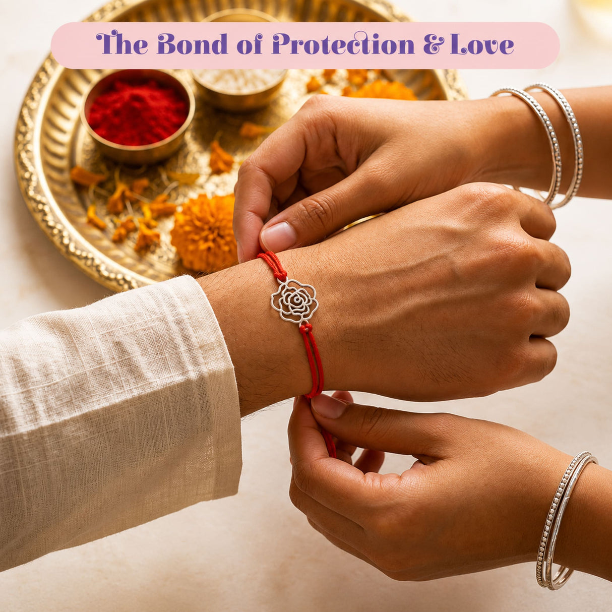 A delicate silver rose charm rakhi bracelet with a red cord being tied for brother and bhabhi protection gift