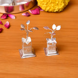 Two silver plated tulsi plant figurines with detailed leaves on engraved square bases for home pooja mandir decor