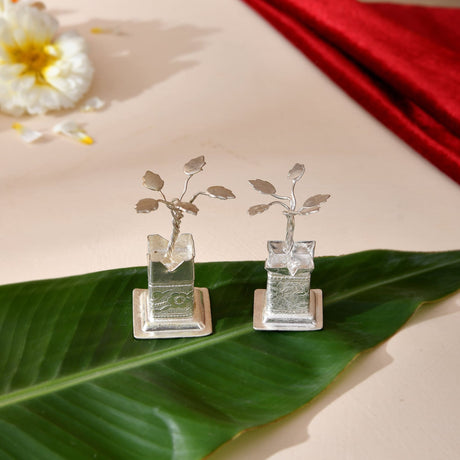 Silver plated miniature tulsi plant figurines with delicate leaves in clear glass pots on ornate silver bases for pooja decor