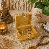 Small handmade golden ornate jewelry box with velvet interior holding gold rings for Indian Punjabi wedding favors