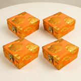 Four vibrant orange brocade fabric jewelry boxes with gold floral patterns and clasps for indian wedding favors