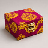 A vibrant magenta handmade fabric jewelry box with golden paisley brocade and brass clasp for Indian and Pakistani wedding favors