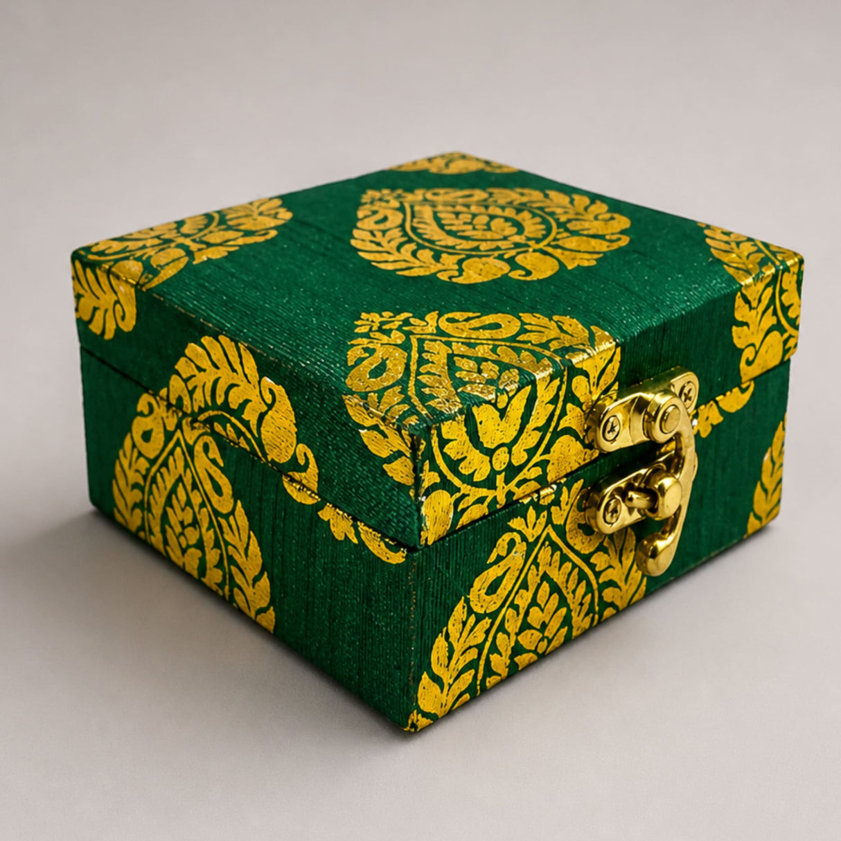 Small handmade jewelry box in green and gold brocade fabric with paisley pattern and brass clasp for indian wedding favors