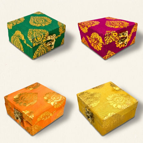 Four ornate small fabric gift boxes in green magenta orange and yellow with gold gota patti brocade and metallic clasp