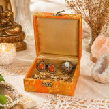 Ornate orange and gold brocade jewelry box with gota patti work and brass clasp containing earrings rings and chains