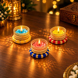 Decorative metal tea light candle holder with three lit colorful wax candles in ornate golden holders for festive gifting