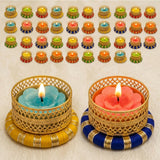 Gold-colored intricately woven small tealight candle holders with vibrant blue and pink floral-shaped candles for festive decor