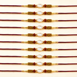 Designer stone rakhi gold plated with central white stone red beads and mesh detailing for Raksha Bandhan protection