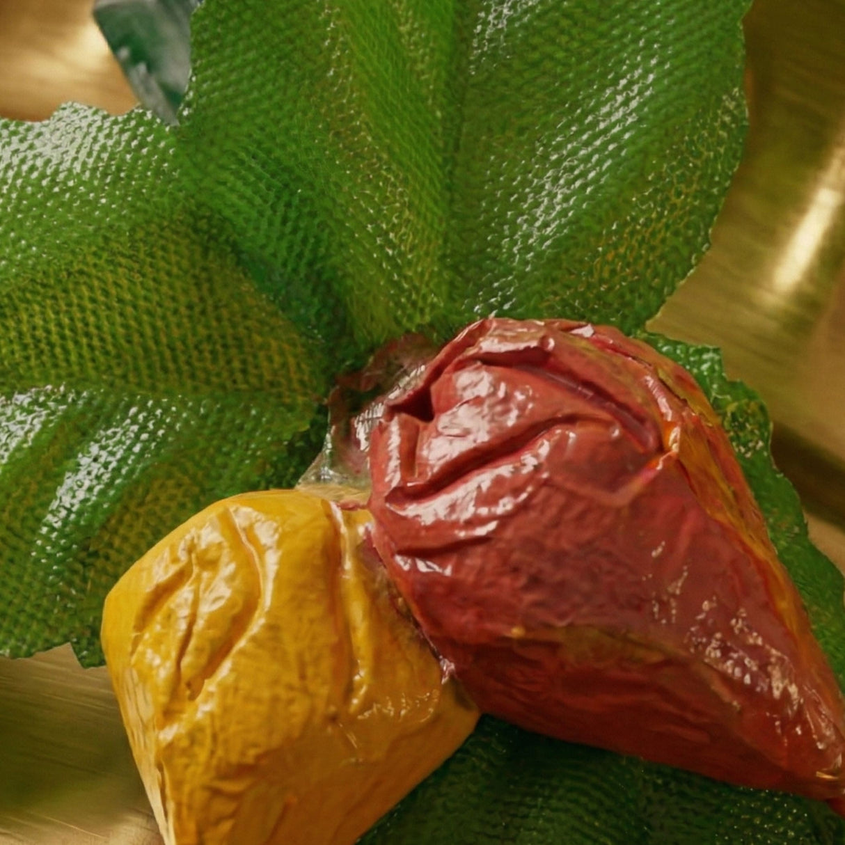 A glossy red and yellow candy-coated fruit-shaped confection in haldi kumkum packets bulk strawberry style mini packs set