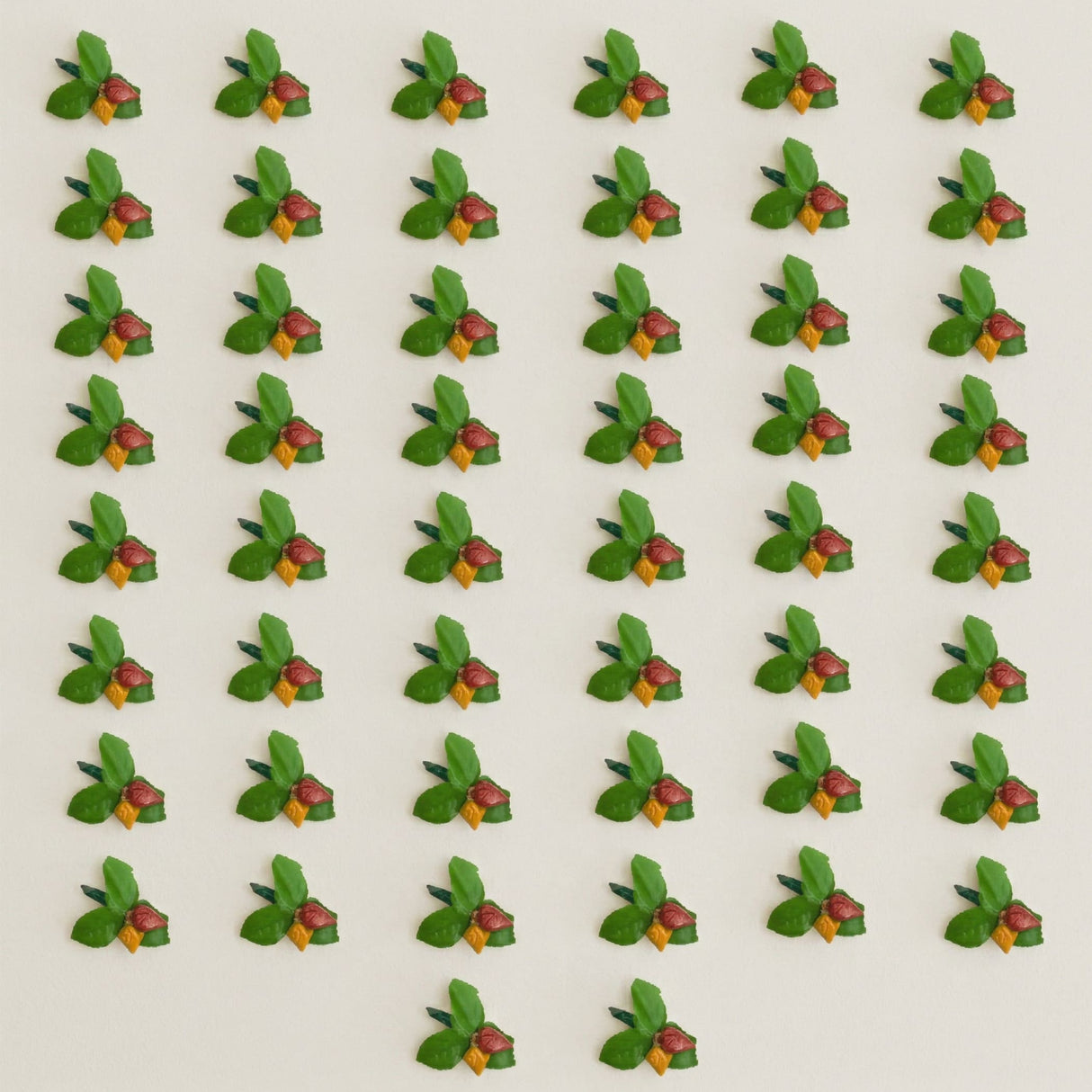 Green and red miniature fruit-shaped decorative pins with yellow accents in haldi kumkum packets bulk strawberry style set