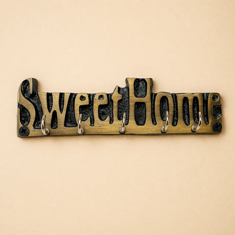 Brass-colored handmade wooden sweet home wall-mounted key holder with black cast metal lettering and five silver hooks