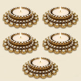 Gold-colored ornate tea light candle holder with clear crystals and intricate metalwork for traditional Diwali and pooja decor