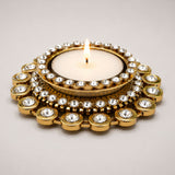 Gold-toned tea light candle holder adorned with clear sparkling crystals in concentric circles for festive home decor
