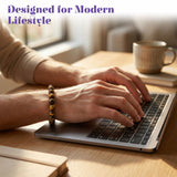 A person wearing a sleek silver laptop and a tiger eye stretch beaded elastic bracelet with 8mm natural stone beads