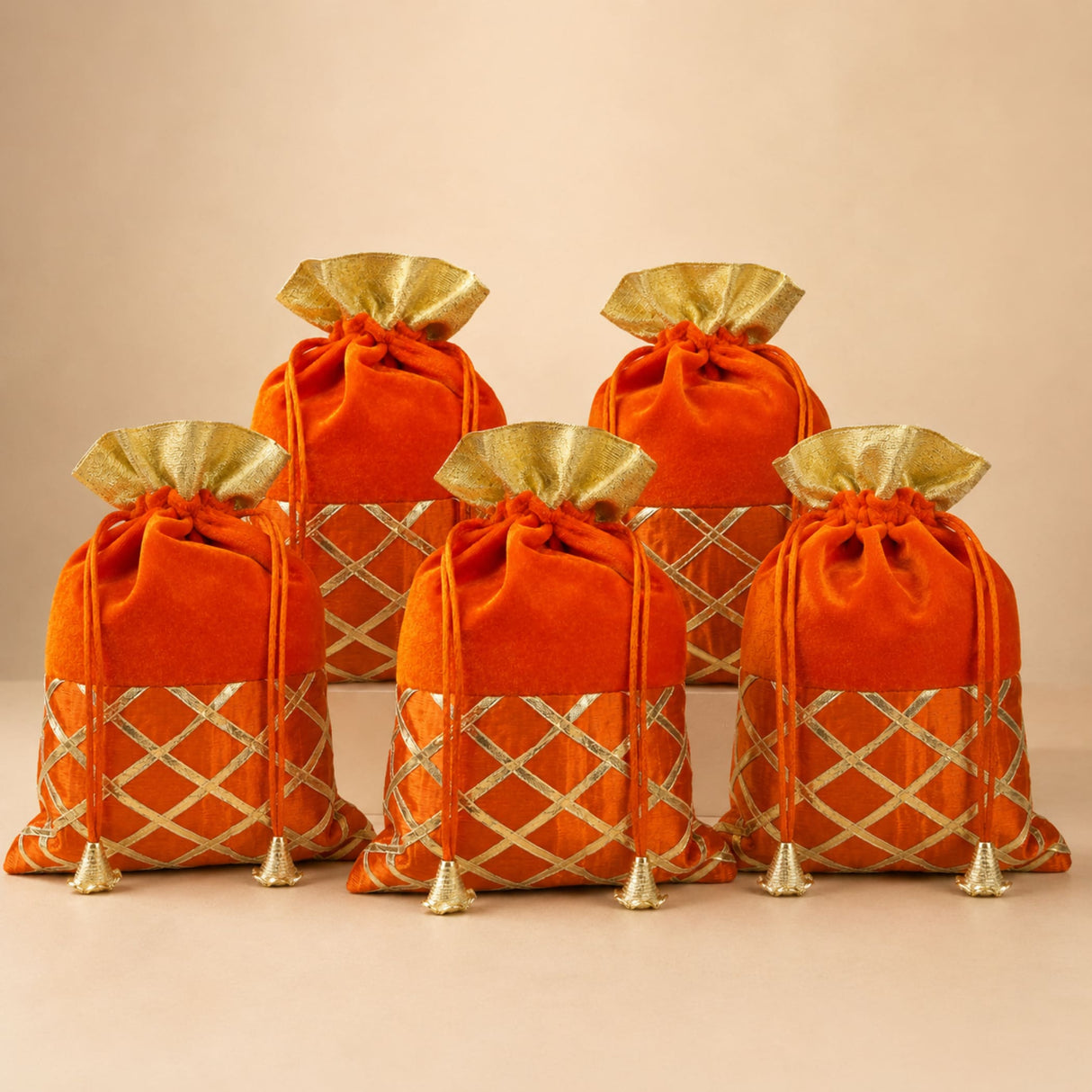 Traditional indian velvet potli bags in orange with gold metallic lattice gota patti work and drawstring ties for festive use