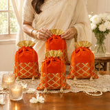 Traditional indian orange velvet potli bags with gold metallic lattice gota patti work for festive and wedding use
