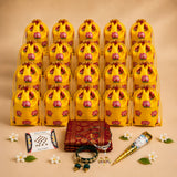 Bright yellow satin drawstring potli bags with pink lotus prints and gold-trimmed tops for hindu festival gift hampers