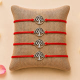 Four red cord tree of life charm rakhis with silver toned circular pendants for brother and bhabhi protection gift