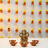 Brass Ganesha idol with five lit clay oil lamps for Diwali decoration