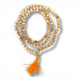 A coiled 5 mm tulsi mala beads necklace with cream wooden beads and an orange tassel for meditation and spiritual wear