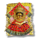 Golden Hindu deity figure with ornate red and green fabric for Varalaxmi Vratam puja