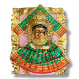 Golden-faced Hindu deity statue with green and orange fabric for Vara Lakshmi idol Puja