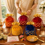 Varalakshmi vratham gift hamper featuring vibrant velvet potli bags in orange red yellow and blue with gold lattice embroidery for pooja and festive use