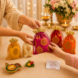 A vibrant magenta drawstring potli bag with intricate gold paisley embroidery and matching golden fabric top for religious gift hampers
