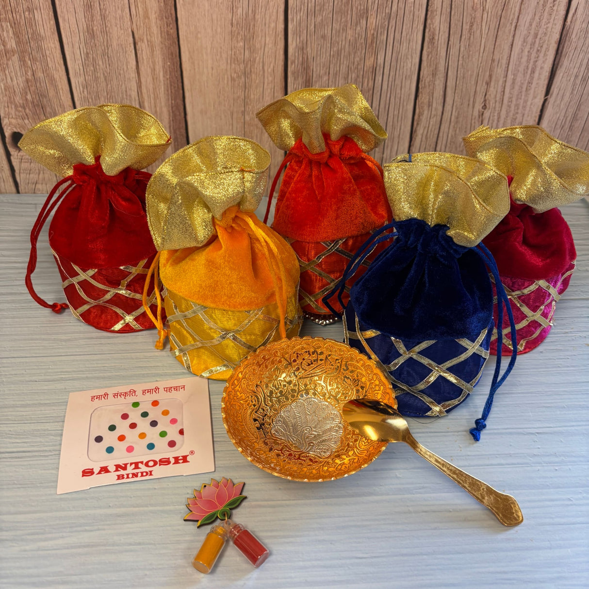 Gold-colored ornate metallic bowl with matching spoon featuring intricate embossed designs in varalakshmi vratham gift hamper