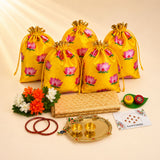 Yellow satin drawstring potli bags with pink lotus prints and gold ties from varalakshmi vratham gift hamper for women