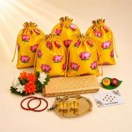 Yellow satin drawstring potli bags with pink lotus prints and gold ties from varalakshmi vratham gift hamper for women