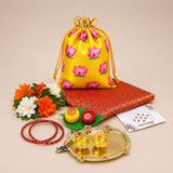Yellow satin drawstring potli bag with pink lotus prints and gold trim for varalakshmi vratham gift hampers and puja use