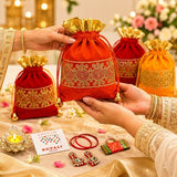 A vibrant red velvet potli bag with intricate gold embroidery and golden ruffled top for varalakshmi vratham gifts