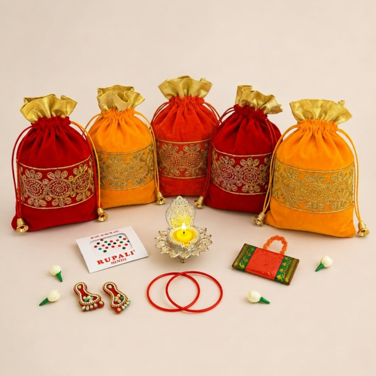 Red and orange velvet drawstring potli bags with gold embroidered bands and golden flaps for navaratri vratha gifts