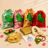Four satin drawstring potli bags in mint green pink gold and red with green parrot design for varalakshmi vratham gift hamper