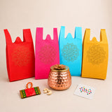 A copper-colored hammered textured pot with a golden flower-shaped lid for varalakshmi vratham gift hamper pooja use