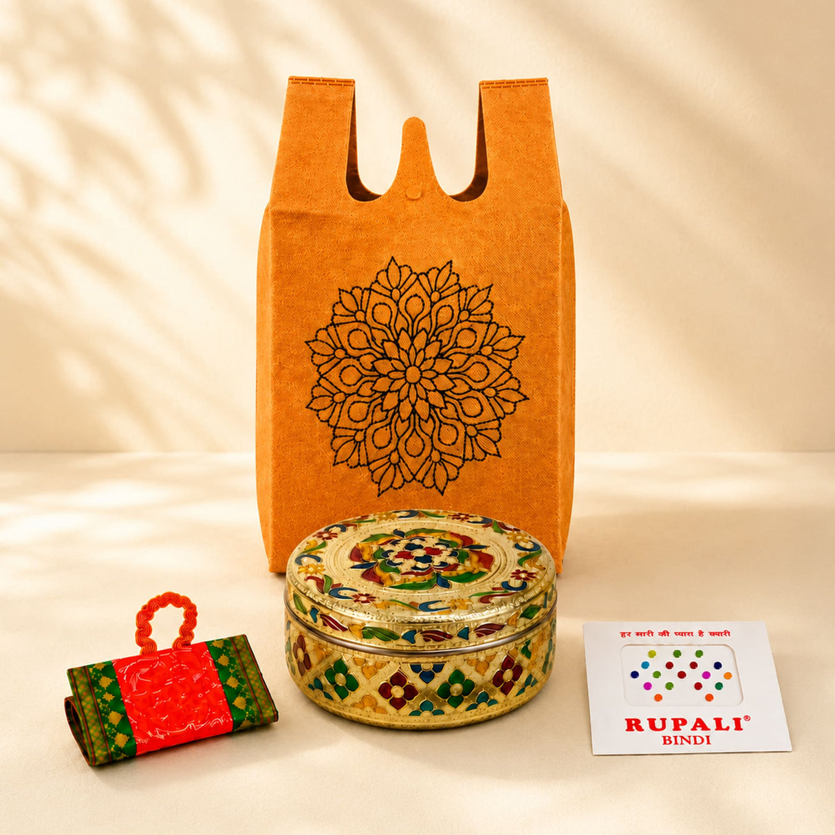 Ornate round metal box with intricate gold green red and blue enamel designs in Varalakshmi Vratham gift hamper for women