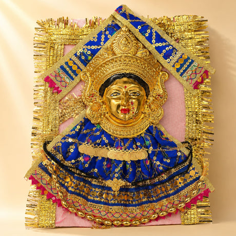 Golden-faced varalaxmi goddess face set adorned with vibrant blue fabric embroidered with gold sequins for pooja rituals