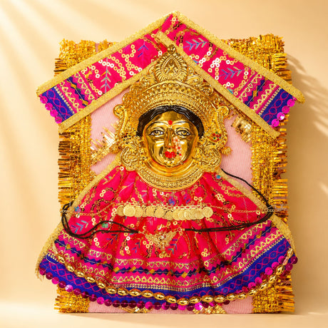 A vibrant pink and gold embroidered Varalaxmi goddess face set with sequins and golden crown for Navaratri pooja