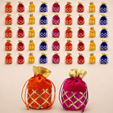 Assorted traditional indian velvet potli bags in orangish red and magenta with gold gota patti lattice embroidery for festive use