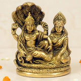 Golden brass statue of lord vishnu and lakshmi ji seated with a coiled shesha naag for mandir pooja and home temple